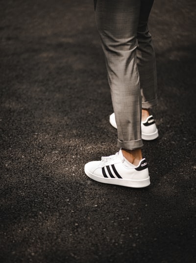 In gray pants, dressed in black and white sneakers
